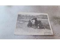 Photo Three young men with a vintage gramophone in a meadow