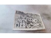 Photo Children with their teacher sitting on a meadow