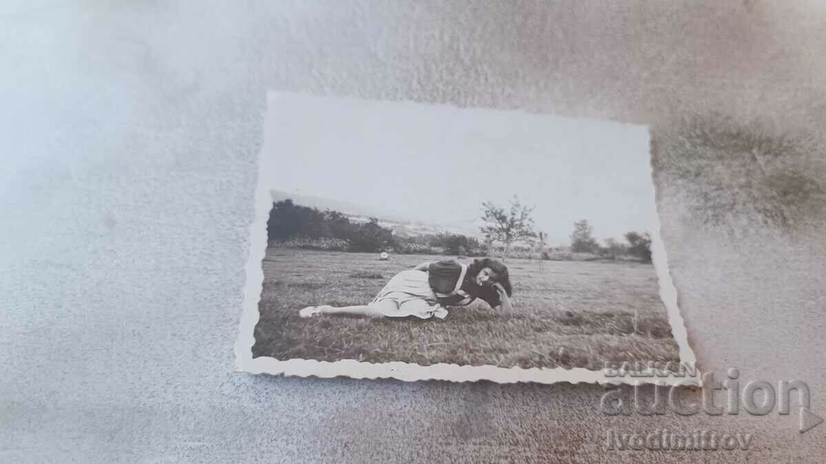 Photo A young girl lying on the grass