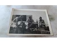 Photo Three men in shorts drinking beer