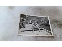 Photo Men in swimsuits sitting on a wooden platform