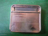 An old snuffbox with a cigarette rolling machine