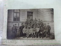 Old photo of a group of men in uniform in front of a building