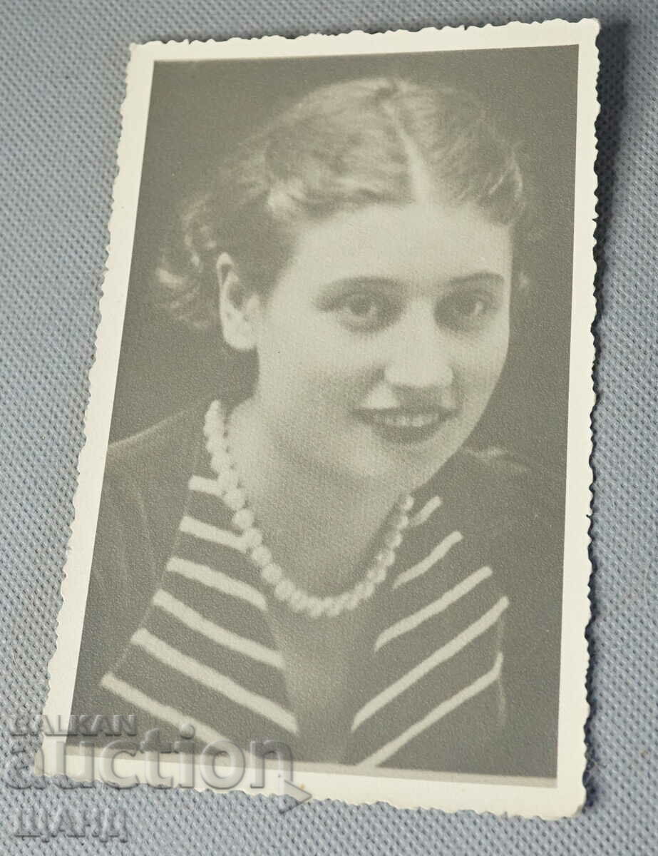 Old postcard photo of a girl with a dress and a necklace