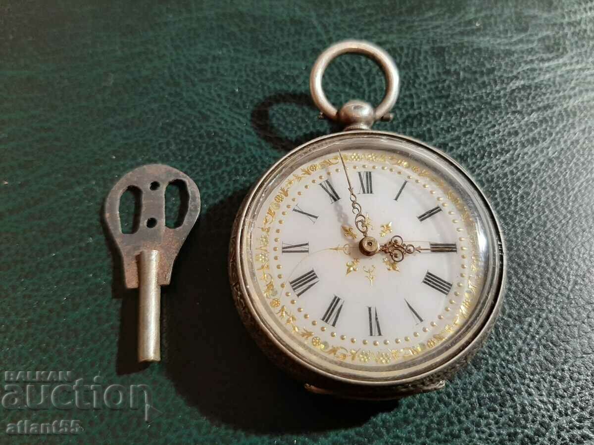 Silver pocket watch with key