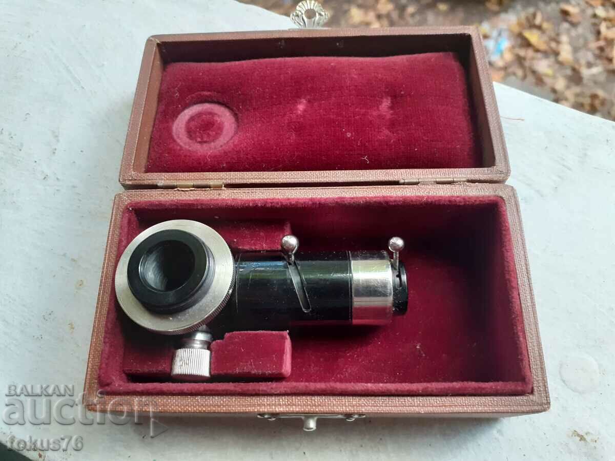 An old microscope instrument in a box