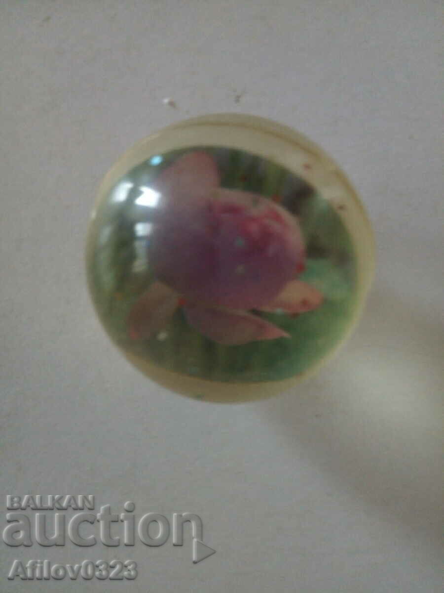 Transparent ball with images of roses embedded in it.