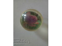 Transparent ball with images of roses embedded in it.