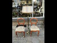 A pair of wooden chairs with embroidery. #6023