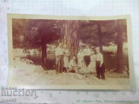 Old photo of a group on an outing in front of the tree