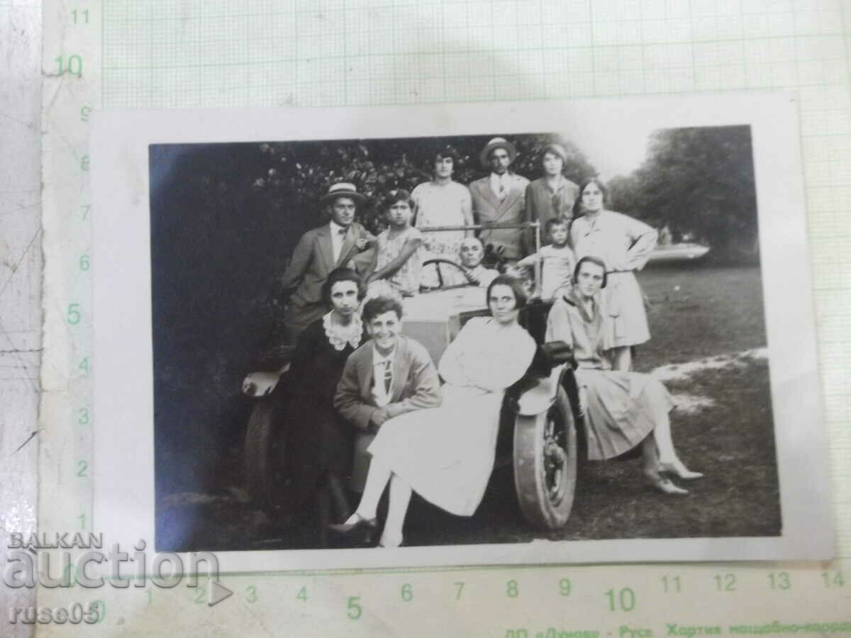 Old photo of a group of young people on a car