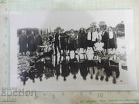 Old photo of a group of young people with two bicycles on the river