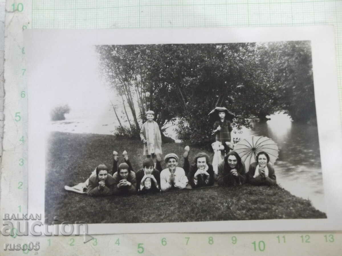 An old photo of a group of young people lying on the bank by the river