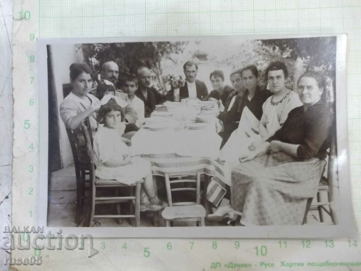 An old photo of a group gathering at a table