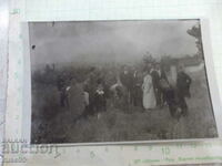 An old photo of a group of young people in front of a pine grove