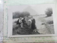 Old photo of a trio by the river