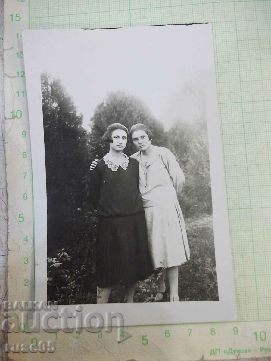 Old photo of two ladies in front of trees