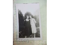 Old photo of two ladies in front of trees