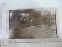 An old photo of a group of young people by the river bridge