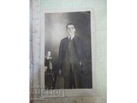 Old photo of a gentleman in a suit next to a table