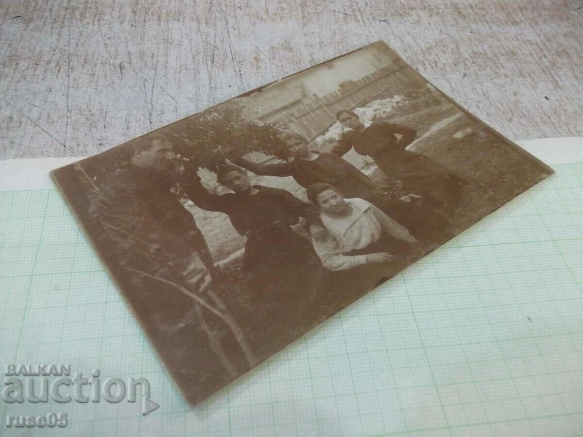 Auction  An old photo of four women and a man in front of a fence