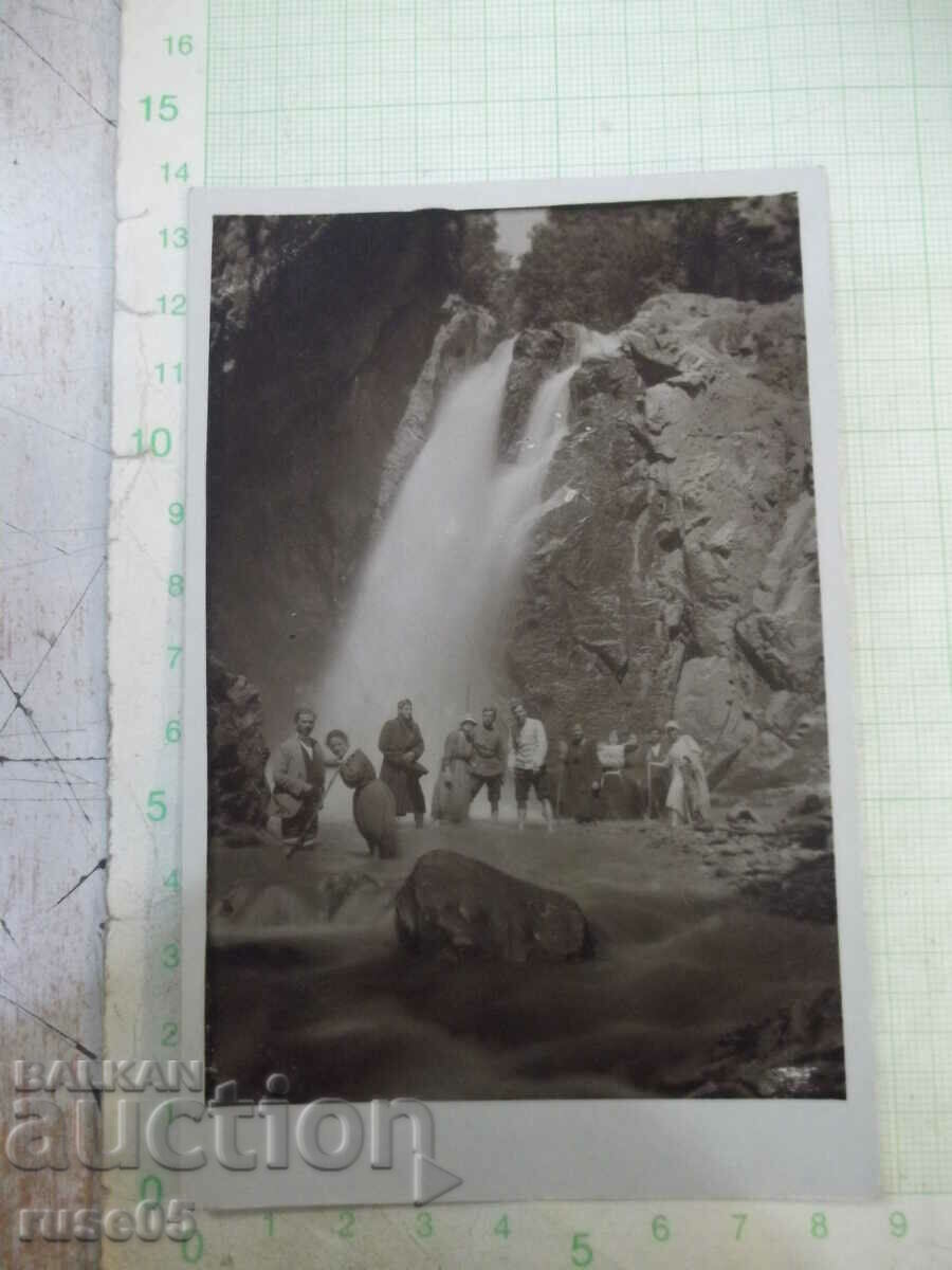 Old photo of a group in front of the waterfall