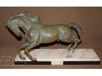 Metal sculpture of a horse with a marble base