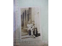 An old photo of a Bulgarian man with a girl in front of a house in America