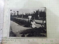 An old photo of a seated woman in a garden path in America