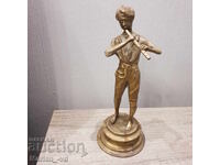 Old brass figure of a boy playing the flute