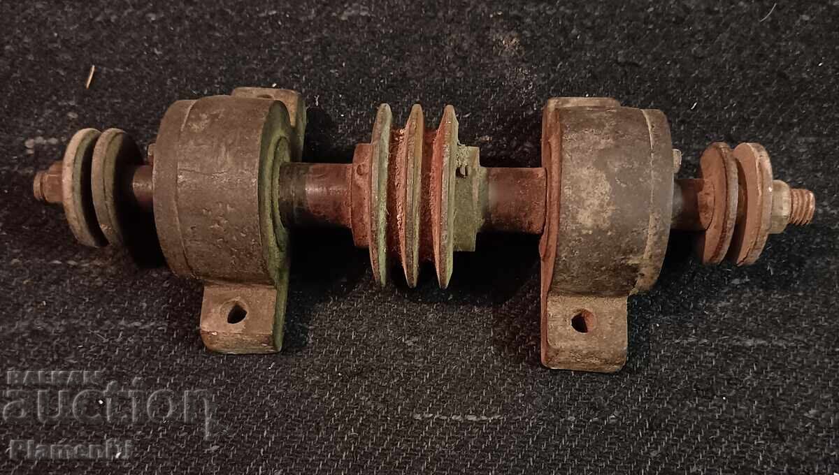 Old axle with bearings for a machine.