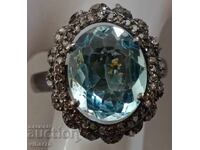 silver ring with aquamarine and surrounded by a scale of diamonds