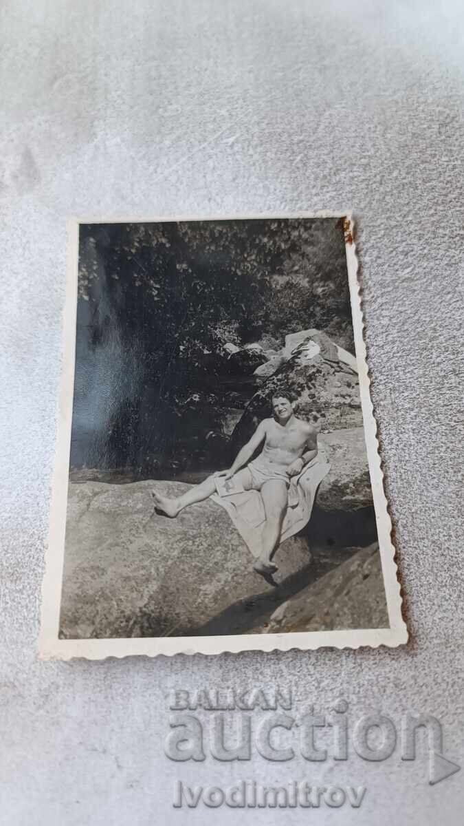 Photo Man in swimsuit on a rock Photo Man in swimsuit on a rock
