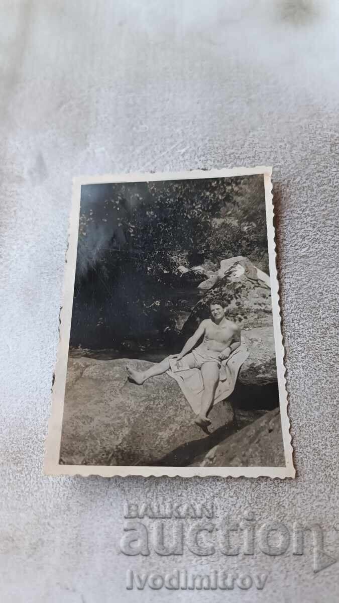 Photo Man in swimsuit on a rock Photo Man in swimsuit on a rock