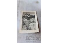 Photo Two young girls on a ladder of a swimming pool