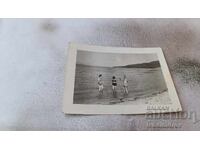 Photo A man and two young girls on the beach