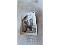 Photo Self-guided Two officers in front of a Colonial store 1944