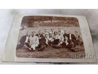 Photo: Young people with a retro gramophone sitting in a meadow