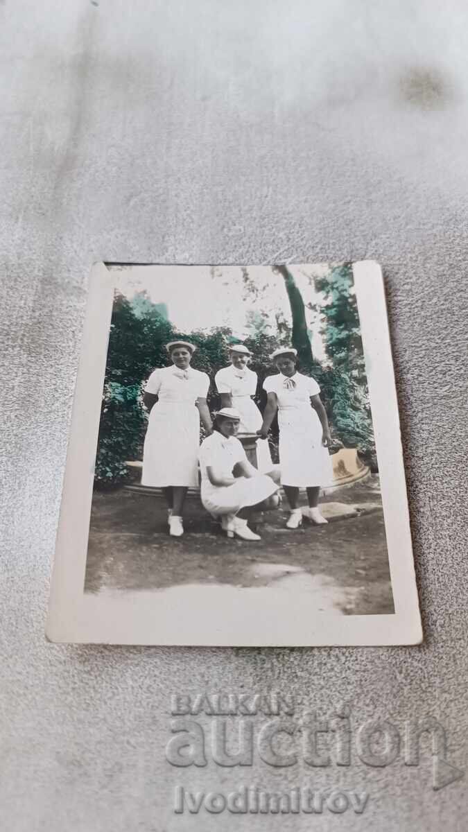 Photo Four young girls in white dresses in the park Photo Four young girls in white dresses in the park