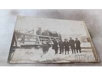 Photo Men and women on a wooden bridge over a river in winter