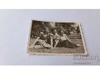 Photo Three young girls sitting on the grass