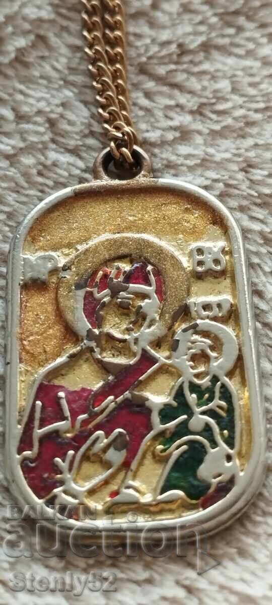Medallion with a cross and the Virgin Mary with the baby. Medallion with a cross and the Virgin Mary with the baby.