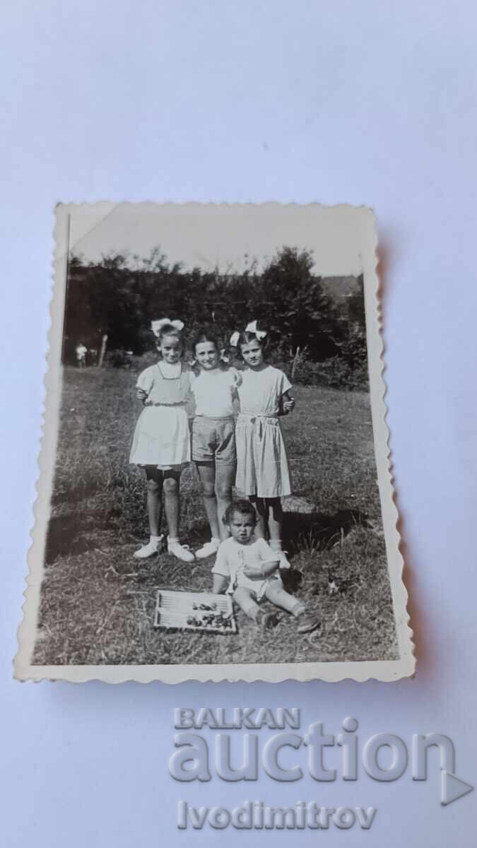 Photo: Three Girls and a Little Boy in a Meadow