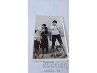 Photo of Three Young Men and a Young Woman on the Beach