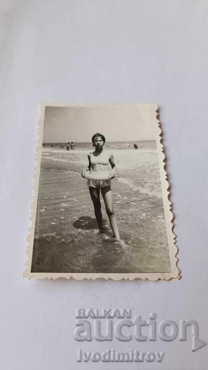 Fotografie Tineră fată cu colac pe malul mării Fotografie Tineră fată cu colac pe malul mării