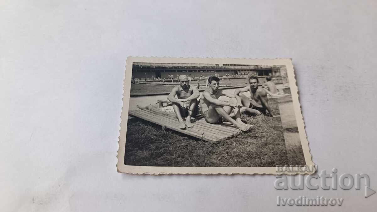 Photo of Three Young Men by a Swimming Pool