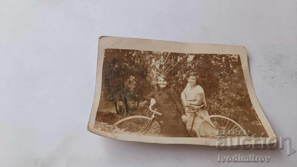 Φωτογραφία Δύο νεαρών κοριτσιών με ρετρό ποδήλατο