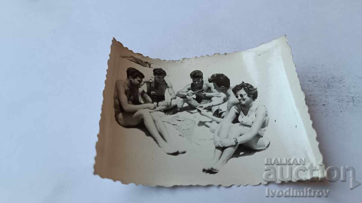 Photo Young people playing cards on the beach