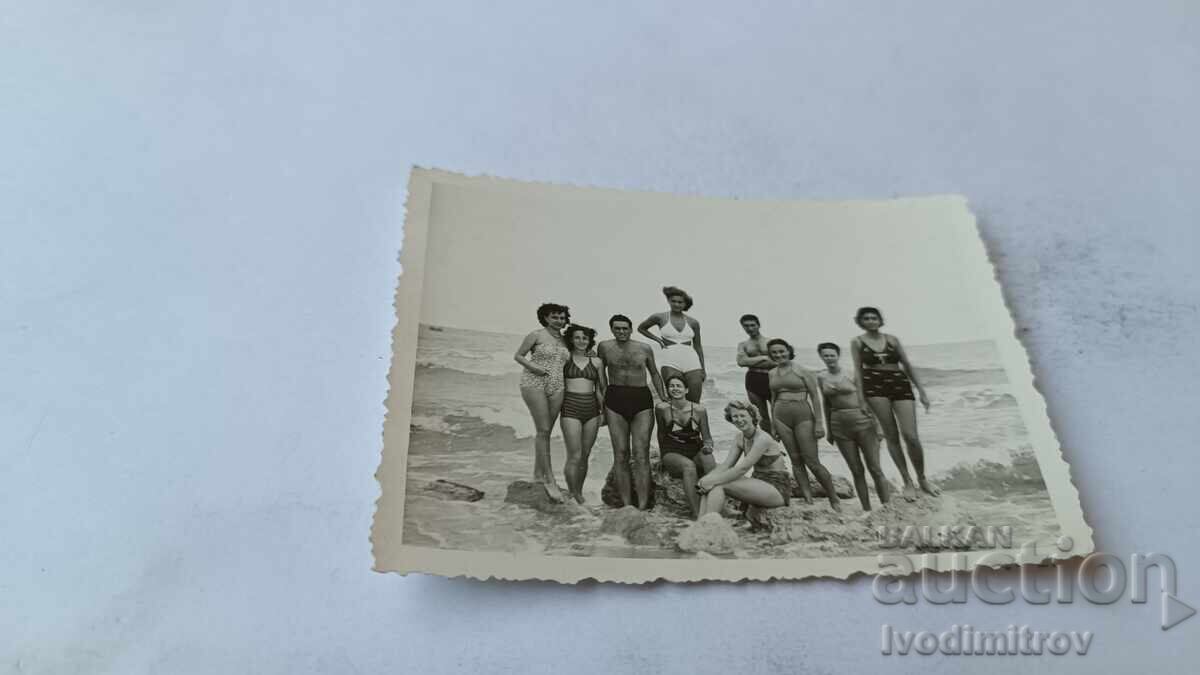 Φωτογραφία Νέων και κοριτσιών σε βράχους στην παραλία