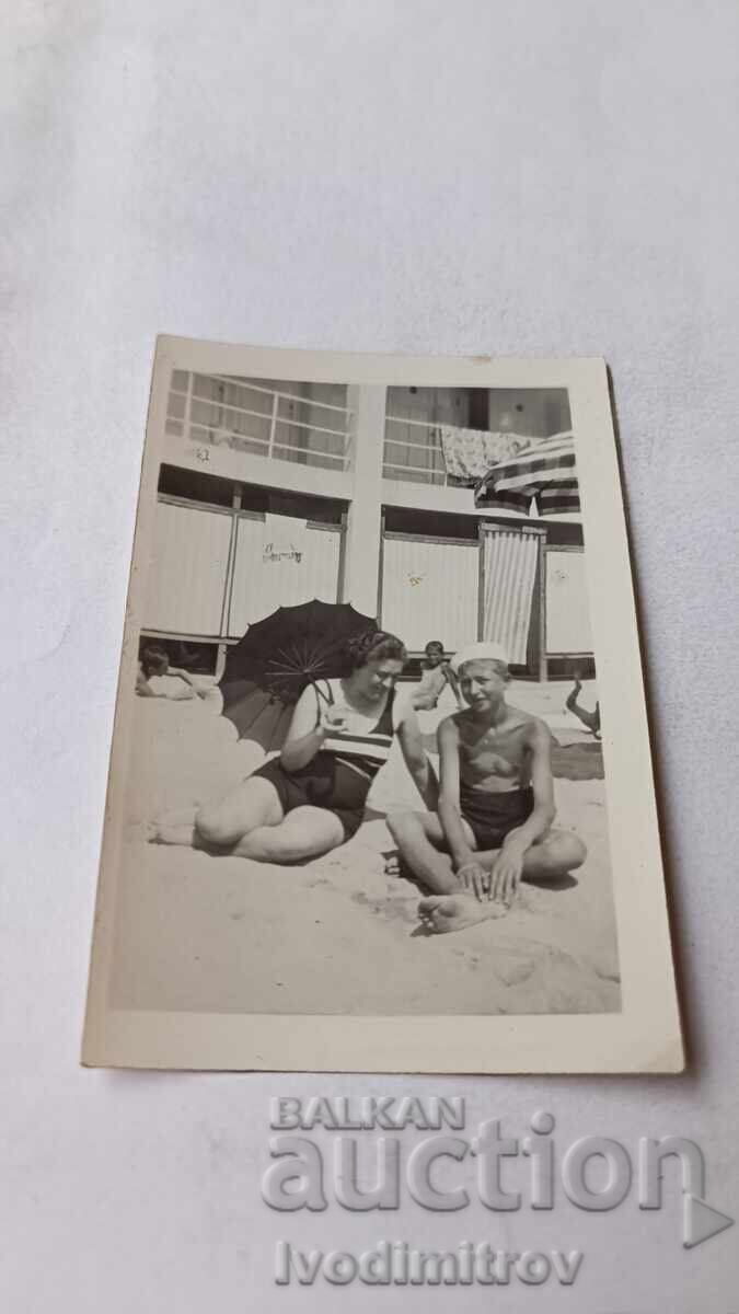 Photo of a Young Man and a Young Woman on the Beach